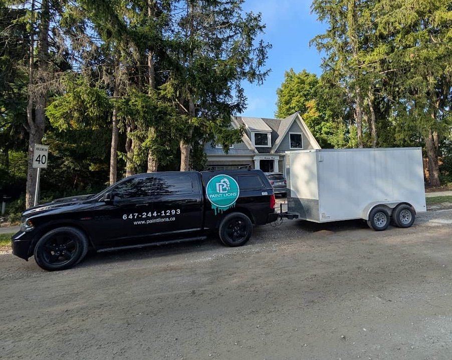 paint lions truck with trailer in front of the house